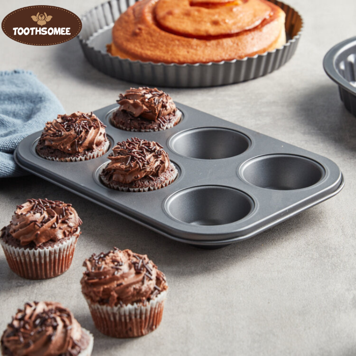 Non-stick 6-cup muffin tray with freshly baked muffins placed on a kitchen counter