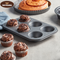 Non-stick 6-cup muffin tray with freshly baked muffins placed on a kitchen counter