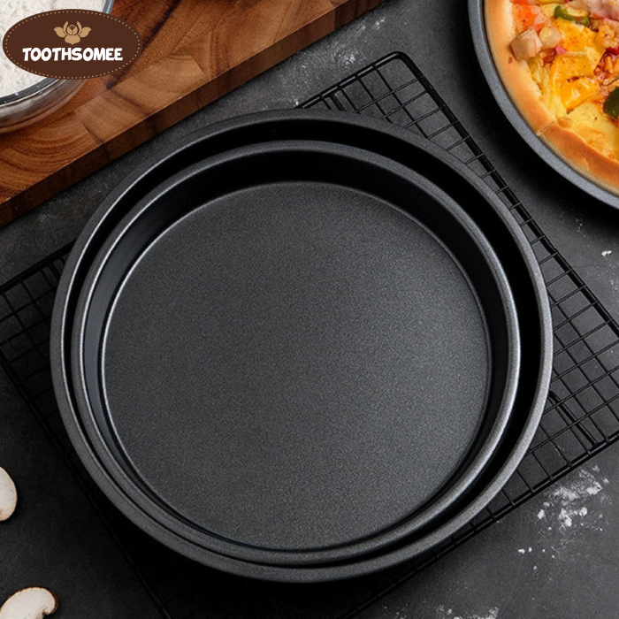 Set of three non-stick round pizza pans in different sizes placed on a kitchen counter